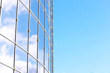 Architectural detail of the facade with multiple reflections of other buildings and the sun. Modern building. Architecture background