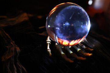 Skeleton Zombie Rising Out Of A GraveYard - Halloween. Mysterious magic ball predictions and smoke on dark scene.