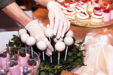 Catering table with sliced chocolate cakes decorated with fresh raspberries and nuts.
