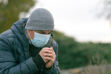 Prevent the spread of the Coronavirus Disease 2019 (COVID-19). Man in park sneezing or coughing...