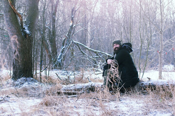 Bearded man in the winter woods. Attractive happy young man with beard walk in the park.