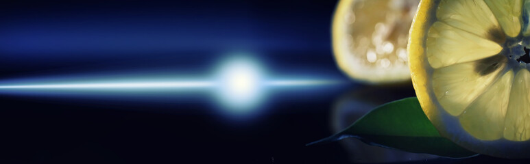 Composition with orange and grapefruit slices on a black background. A slice of orange with back light on a black background with water drops. Juicy orange on a table.