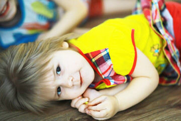 Portrait of a small child lying on the floor in a room decorated with balloons. Happy childhood concept.