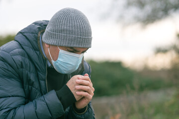 Prevent the spread of the Coronavirus Disease 2019 (COVID-19). Man in park sneezing or coughing...