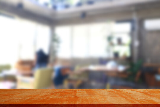 empty wood table in front of blur coffee shop / restaurant background.