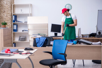 Young male contractor cleaning the office