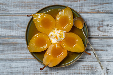 Baked pears in orange juice with ice cream, close up. Delicious dessert.