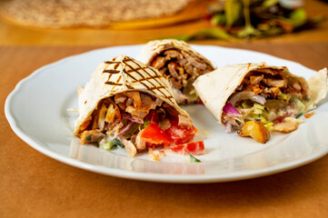 3 sliced piece of kebab on white plate on table.