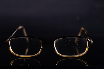 Fototapeta na wymiar brown glasses on a black background