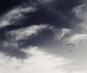 Silhouette of skydiver at sky