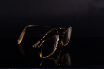 brown glasses on a black background