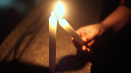 close shot of person lighting candle with another candle and hence spreading light health joy and happiness with others on the festival of diwali, christmas, new year and more