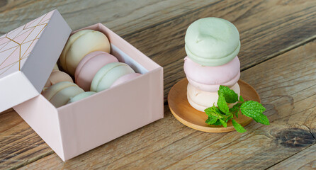 Gift box with homemade pastel multi color marshmallows. Apple zephyr in round shape. delicious fruit dessert on wooden table