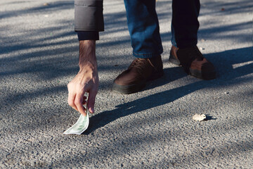 man picks up lost money in the city.