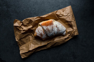 Delicious croissant on paper in natural light