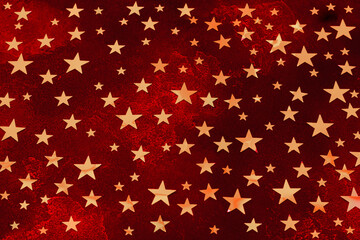Bright Deep red Christmas stone background of stars colored in Fortuna Gold, golden starlets