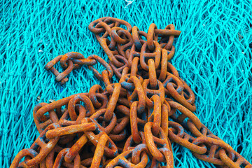 Rusty shackles on a blue fishing net
