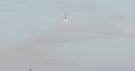 Rocket booster landing propulsively at launch site.