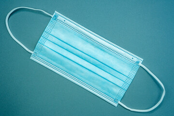 Antibacterial medical mask of blue color on a blue background. Coronavirus Protection concept.