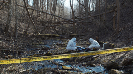 Detectives are collecting evidence in a crime scene. Forensic specialists are making expertise....