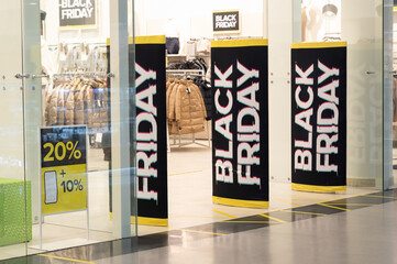 Empty entrance to the clothing store with Black Friday banners (selective focus)