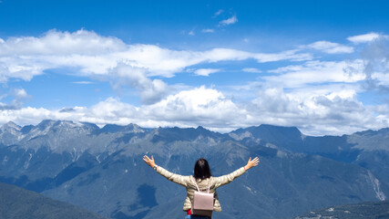 Embrace the world. Happy young woman traveling in the mountains.