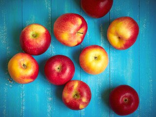 Bright red and yellow apples on a blue background.