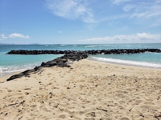 sandy and rocky seashore against the blue sky in the tropics