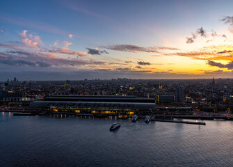 View on the historic city center of Amsterdam with the central train station and river IJ during...