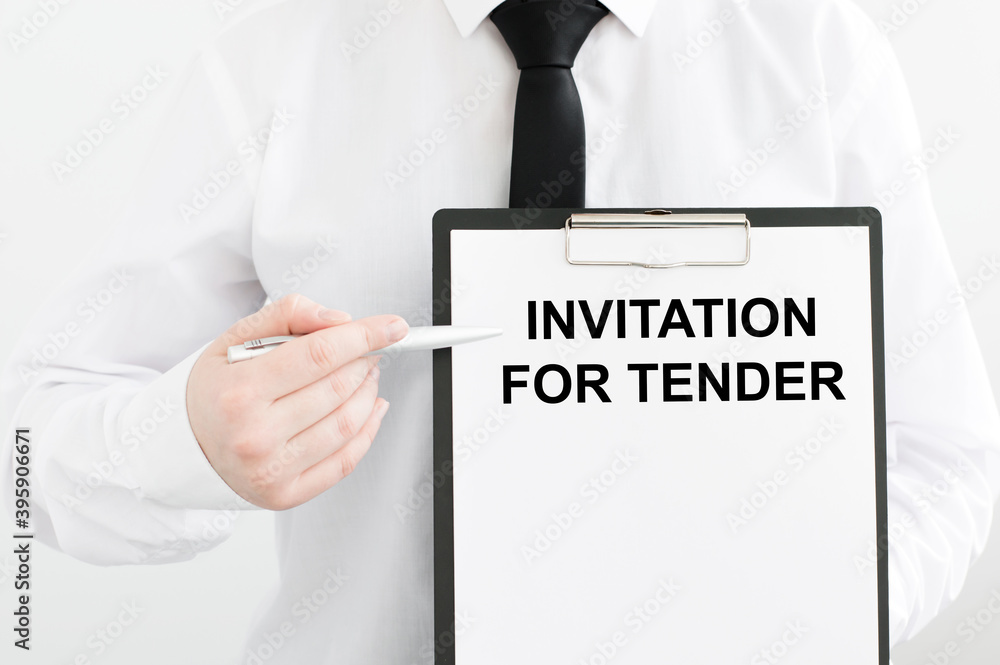 Aufkleber card with text invitation for tender in the hands of a man on a light background