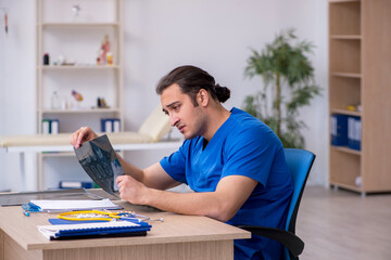 Young male doctor radiologist being unhappy after night shift