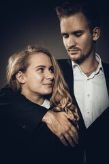 Young beautiful couple studio portrait on grey background.