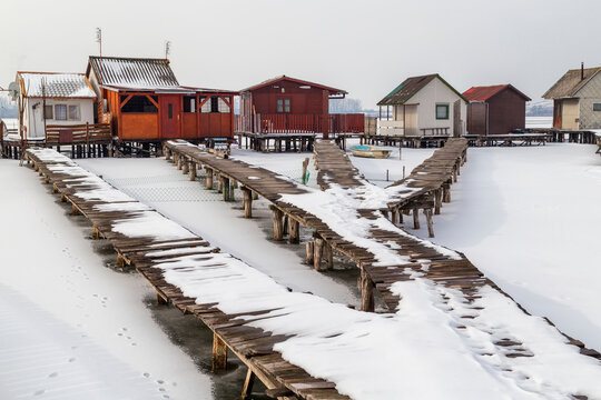 View of the famous floating village at wintertime. Frozen lake, snowy landscape. Bokod,Hungary.