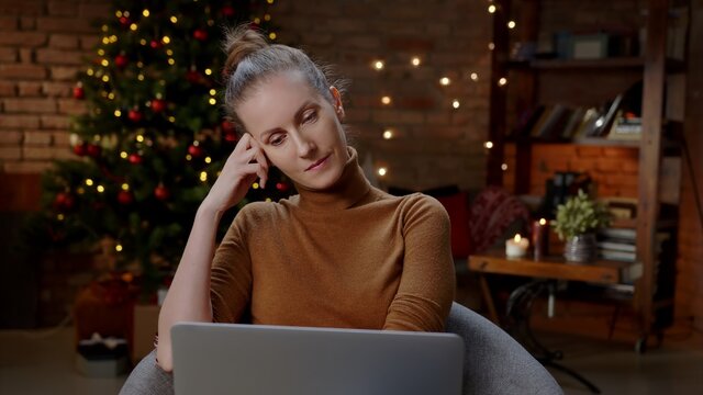 Woman working on laptop computer at home in winter at Christmas in December, Winter.