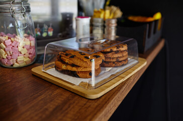 Tasty cookie at bar counter in coffee shop. Blurred image, selective focus