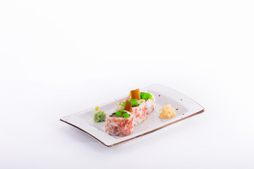 delicious looking uramaki pieces with wasabi and pickled ginger on a small tray on a light background.