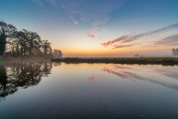 Naklejka na ściany i meble Dutch polder landscape with colorful sunrise