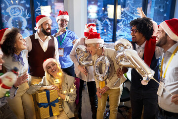 Group of happy colleagues at New Year eve company party. New Year, holiday, party, people concept