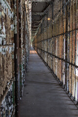 Abandoned Prison Interior. Row of empty cells on cell block of abandoned prison in vertical orientation.