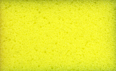 Texture of yellow dishwashing sponge. Abstract yellow background.