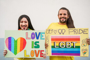 Happy transgender people holding lgbt banners outdoor - Gay pride and protest concept