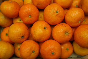 Close up of many ripe raw orange mandarins for natural food background (focus on center)