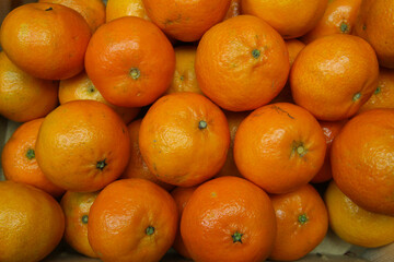 Close up of many ripe raw orange mandarins for natural food background (focus on center)