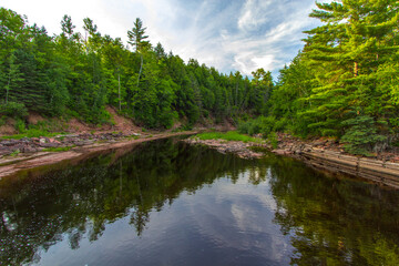 Obraz premium Forest River Landscape. Boreal forest wilderness scene and river on the Prickett River in the Upper Peninsula of Michigan.