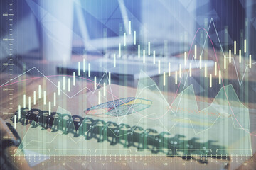 Double exposure of financial graph drawings and desk with open notebook background. Concept of forex market