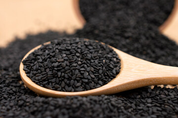 Black sesame seeds in wooden spoon,Close up.