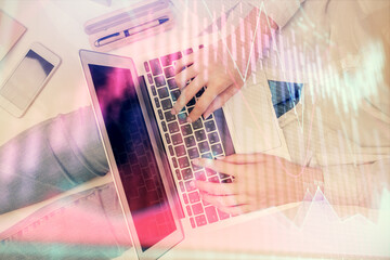 Double exposure of woman hands working on computer and forex graph hologram drawing. Top View. Financial analysis concept.