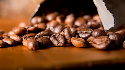 Roasted coffee beans scattered from the packaging on a silver background, close-up, space for text, Wallpaper, postcard, texture, background
