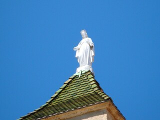 Obraz premium white statue of the virgin mary against blue sky