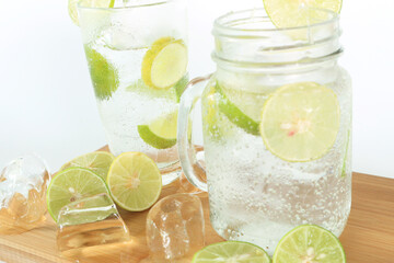 Health care, fitness, healthy nutrition diet concept. Fresh cool lemon infused water, detox drink, lemonade in a glass jug and a glass.